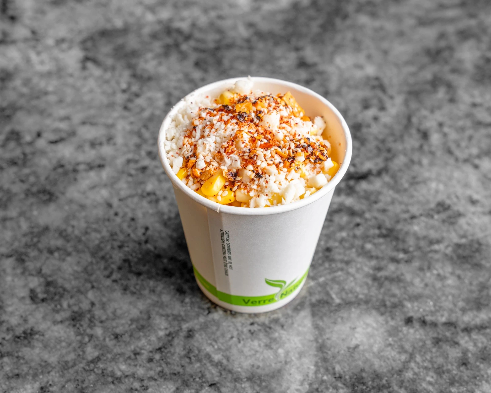 Mexican Street Corn (Elote) — grilled corn on the cob topped with crema, cotija cheese, chili powder and lime, served at El Cafesito By Mexicanada Edmonton